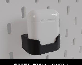 May include: A white wireless charging case for earbuds is mounted on a black 3D printed wall mount. The mount is designed to fit a pegboard wall.