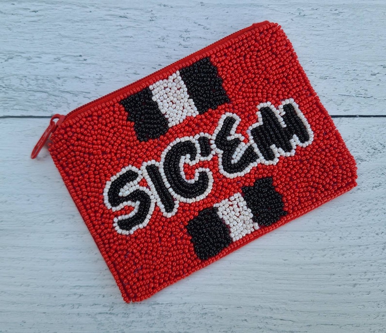 Pu&ograve; includere: Porta monete rosso con perline, con un motivo a scacchi bianco e nero e la parola "SICK" in lettere nere.
