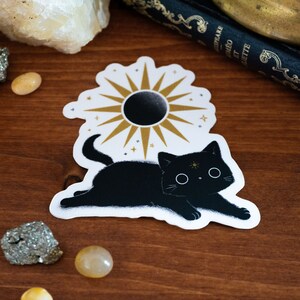 Autocollant 'Golden Hour' avec un motif de chat de sorcière noir avec un soleil et des étoiles - autocollant en vinyle mat de haute qualité