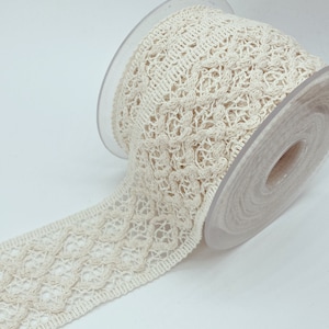 May include: A roll of off-white crocheted lace trim with a delicate floral pattern.