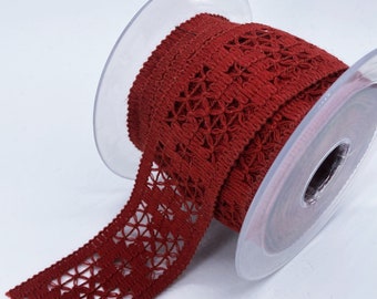 May include: A spool of red crochet trim with a delicate floral pattern. The trim is wound around a clear plastic spool.