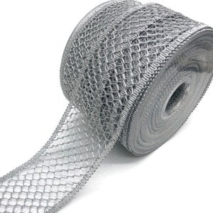 Könnte beinhalten: Eine Rolle silbernes, metallisches Netzband mit einem gewellten Rand. Das Band ist aufgerollt und ein Teil des Bandes ist abgewickelt, wodurch die Textur des Netzes sichtbar wird.