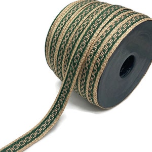 Pode incluir: Um rolo de fita de juta listrada verde e marrom. A fita é tecida com um padrão repetido de listras verdes e marrons.