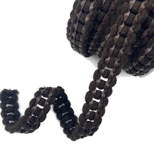 May include: Brown braided trim with a leather-like finish. The trim is woven with a series of small loops and has a textured appearance.