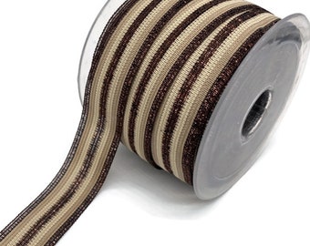 May include: A roll of brown and beige striped elastic ribbon with a metallic sheen. The ribbon is wound around a clear plastic spool.