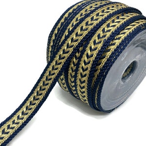Può includere: Un rotolo di passamaneria blu navy e oro con un motivo a chevron. La passamaneria è tessuta e ha una lucentezza discreta.