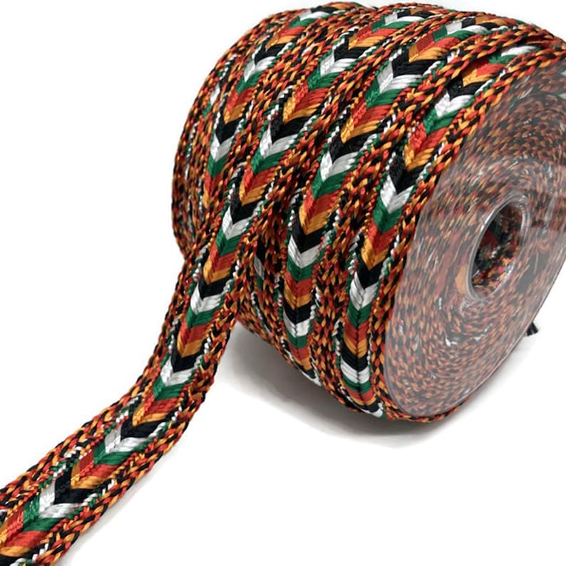May include: A roll of black, red, green, gold, and white braided trim with a chevron pattern.