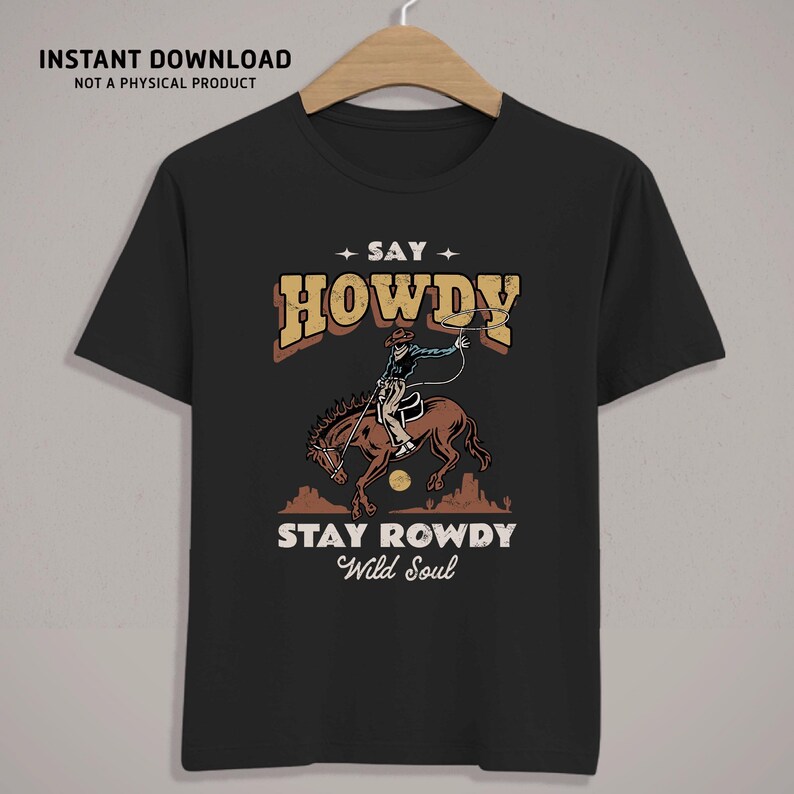 K&ouml;nnte beinhalten: Schwarzes T-Shirt mit einer Vintage-Illustration eines Cowboys, der ein Pferd reitet und ein Lasso wirft. Der Text "Say Howdy Stay Rowdy Wild Soul" ist auf dem T-Shirt aufgedruckt.