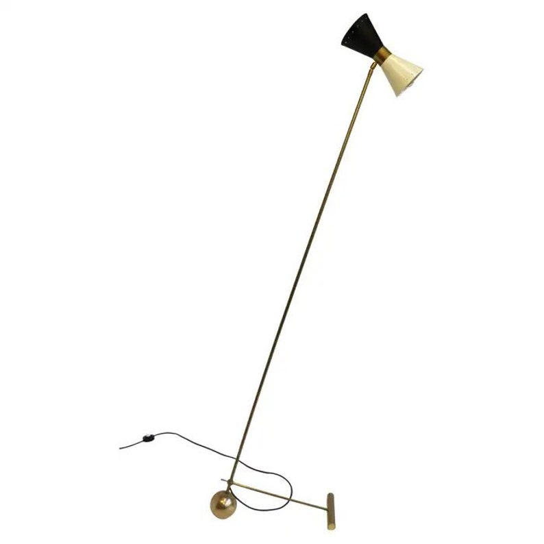 May include: A brass floor lamp with a black and white shade. The lamp has a long, adjustable arm and a round base.