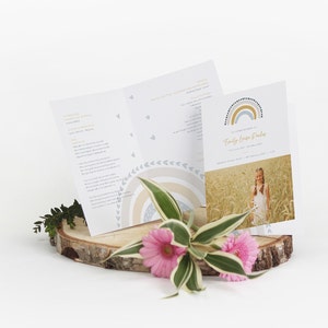 May include: A folded programme for a memorial service featuring a rainbow design and the name "Emily Louise Parker" printed on the front. The programme includes a photograph of a young girl in a white dress standing in a field of tall grass.