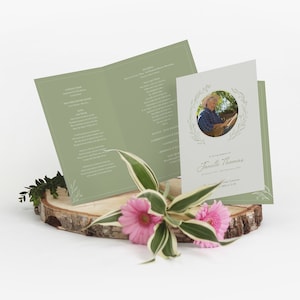 May include: A green and white funeral order of service with a photo of a woman in a floral wreath. The order of service includes the text "In loving memory of Janelle Thomas" and the date "03 January 1942 - 21 November 2021".