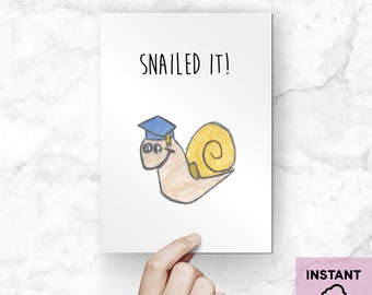 May include: A greeting card featuring a snail wearing a graduation cap. The card reads "SNAILED IT!" in black text.