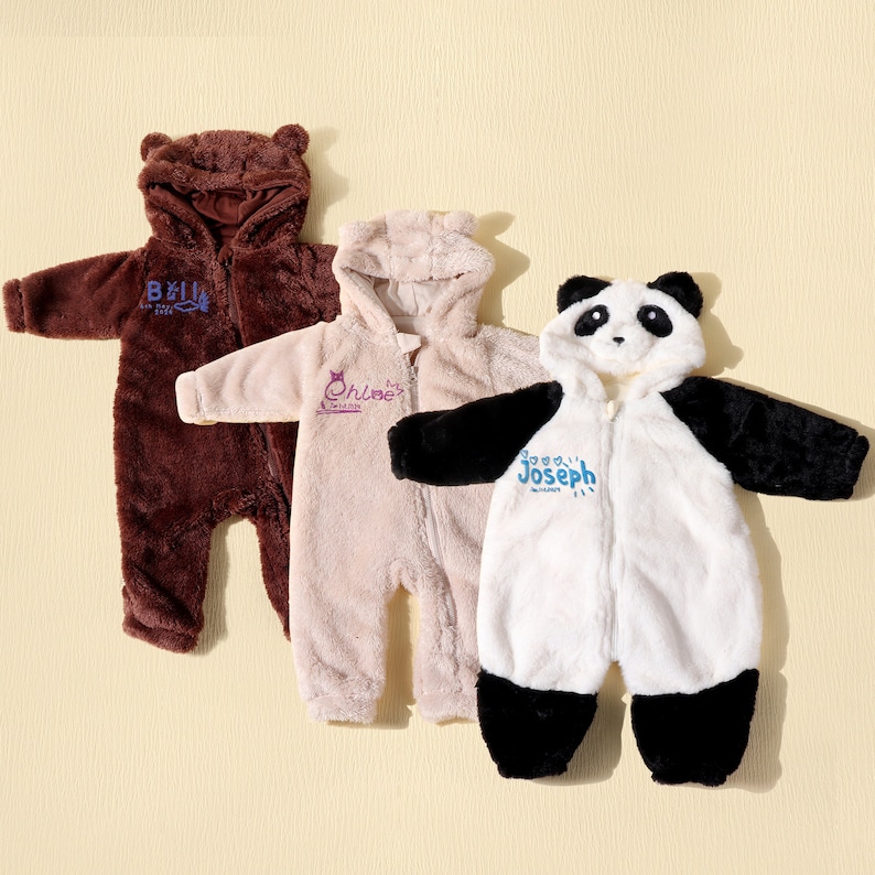 May include: Three plush baby onesies in brown, tan, and white with attached hoods. The brown onesie has bear ears and the name "Bell" embroidered in blue. The tan onesie has the name "Chloe" embroidered in purple. The white onesie is designed as a panda with the name "Joseph" in blue.