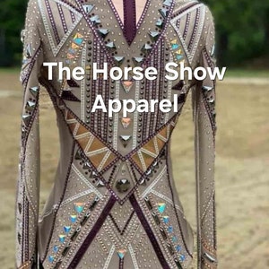 May include: A beige show shirt with a geometric design featuring white, brown, and purple accents. The shirt is embellished with rhinestones and has a high collar. The text "The Horse Show Apparel" is printed on the back of the shirt.
