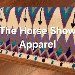 Könnte beinhalten: Eine weiße Satteldecke mit einem farbenfrohen geometrischen Muster in den Farben Lila, Türkis und Braun. Die Decke hat einen braunen Rand und der Text "The Horse Show Apparel" ist in der Mitte aufgedruckt.
