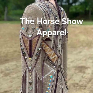 May include: A beige show jacket with intricate geometric designs and rhinestones. The jacket features a high collar and long sleeves. The text "The Horse Show Apparel" is visible on the jacket.