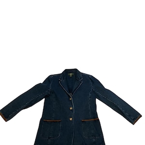 May include: A dark blue denim blazer with brown trim on the pockets and cuffs. The blazer has three gold-colored buttons and two front pockets. The jacket is spread out on a white background.