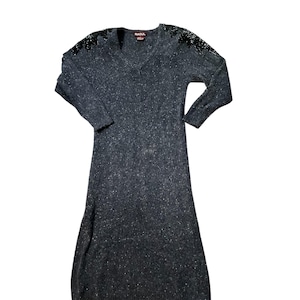 May include: A dark grey, long-sleeved sweater dress with a V-neck. The dress has a subtle sparkle throughout and decorative black embellishments on the shoulders. The brand name "RAOUL" is visible on the back of the neck.