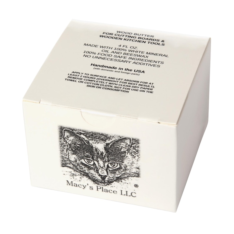 May include: A white box of wood butter for cutting boards and wooden kitchen tools. The box features a black and white illustration of a cat's face and text that reads "Macy's Place LLC". The box contains 4 fl oz of wood butter.