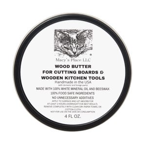 May include: A round tin of wood butter for cutting boards and wooden kitchen tools. The label features a cat illustration and text that reads "Macy's Place LLC" and "4 FL OZ."