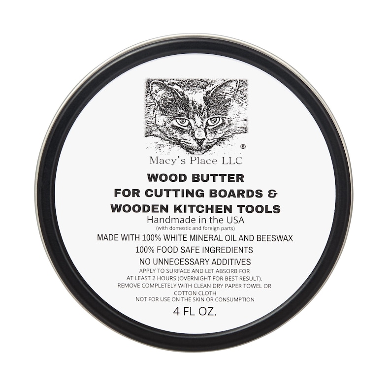 May include: A round tin of wood butter for cutting boards and wooden kitchen tools. The label features a cat illustration and text that reads "Macy's Place LLC" and "4 FL OZ."