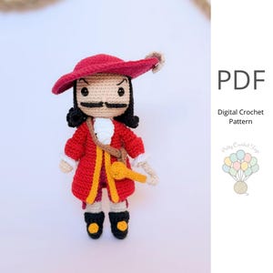 Könnte beinhalten: Gehäkelte Captain Hook-Puppe in rotem Mantel, Hut und schwarzen Stiefeln. Die Puppe hat einen schwarzen Schnurrbart, schwarzes Haar und ein beiges Gesicht. Ein gelber Schlüssel hängt an einem braunen Riemen. Der Text "PDF Digital Crochet Pattern" ist enthalten.