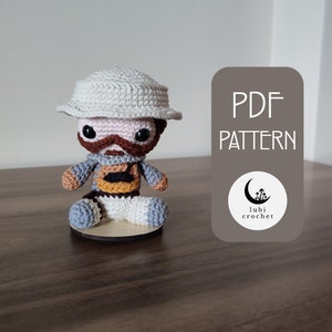May include: Crochet amigurumi pattern for a character wearing a white hat, brown vest, and blue pants. The pattern is available as a PDF download. The image includes the text "PDF PATTERN" and a logo with the text "lubi crochet".