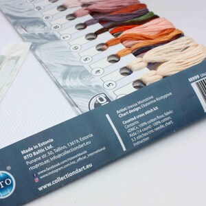 May include: A close-up of a cross stitch kit with a variety of coloured threads, a piece of Aida fabric, and a needle. The kit includes instructions and a chart for the design. The kit is made in Estonia by RTO Baltic Ltd. and is available on the website www.collectiondart.eu.