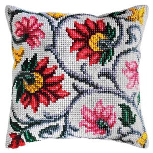 May include: A white pillow with a floral design. The flowers are red, pink, yellow, and green. The pillow is made of a soft, comfortable fabric.