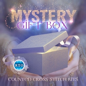 Könnte beinhalten: Eine lavendelfarbene Geschenkbox mit offenem Deckel, die ein helles Licht offenbart. Die Box wird von Händen gehalten, mit einem Band und dem Text "MYSTERY GIFT BOX" darüber. Der Text "COUNTED CROSS STITCH KITS" steht darunter.