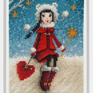 May include: A cross-stitch pattern of a girl wearing a red coat and white hat, holding a star-shaped wand. She is sitting on a snowy hill with a red heart in front of her.