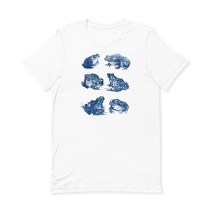 K&ouml;nnte beinhalten: Wei&szlig;es T-Shirt mit einem blauen Aufdruck von sechs Fr&ouml;schen in verschiedenen Posen.