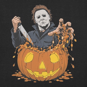 May include: A graphic illustration on a black background featuring a character with a white mask and dark hair wearing a dark jacket. The character holds a silver knife in one hand and reaches out with the other over a carved orange jack-o'-lantern.