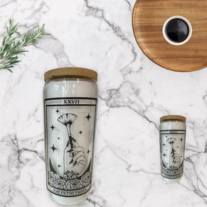 El vaso de cristal de la carta del Tarot Esteticista con tapa y pajita