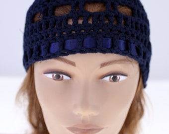May include: A navy blue crocheted hat with a wide brim and a ribbon trim. The hat is made of a soft, lightweight yarn and has a comfortable fit.