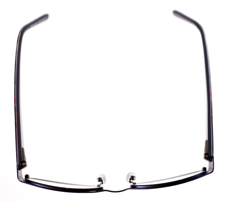 May include: A pair of eyeglasses featuring a black frame and temples. The temples display a subtle red and black pattern. The lenses are clear, and the nose pads are small and transparent. The glasses are set against a white backdrop.