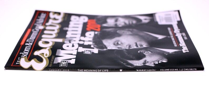 Puede incluir: Revista Esquire, n&uacute;mero de enero de 2010, con el titular "The Meaning of Life". La portada es negra con texto blanco y rojo, y presenta retratos de figuras hist&oacute;ricas. La revista est&aacute; sobre una superficie blanca.