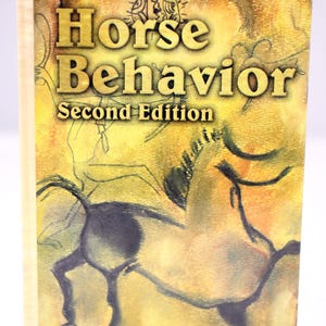May include: Book cover for "Horse Behaviour, Second Edition" by George H. Waring. The cover shows a stylized illustration of a horse in dark colours against a yellow and brown background. The title is in large gold letters.