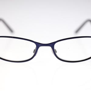 May include: Eyeglasses with a dark blue frame and clear lenses. The glasses have a rectangular shape with rounded edges. The temples are black. The glasses are designed for vision correction.