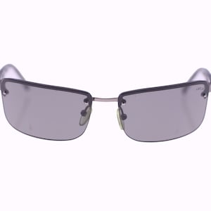 May include: Silver frame sunglasses with gray lenses. The sunglasses have a rectangular shape and a sleek, modern design.