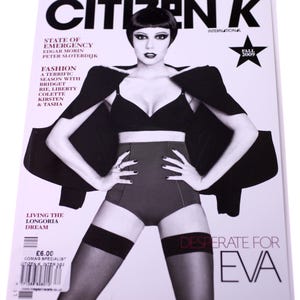 Puede incluir: Una portada de revista en blanco y negro con una mujer que lleva un sujetador negro y pantalones cortos de cintura alta. La revista se titula "Citizen K" y el texto de la portada dice "Desperate for Eva".
