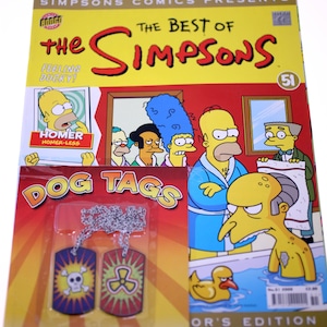 Könnte beinhalten: Die Simpsons Comic-Ausgabe #51 mit einem Coverbild von Homer Simpson im Bademantel, mit dem Text "The Best of The Simpsons" und "Feeling Ducky!"  Die Comic-Ausgabe enthält einen Satz Hundemarken mit einem Totenkopf und Knochen und einem Strahlungssymbol.