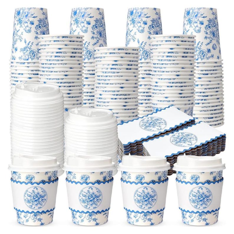 May include: A collection of disposable coffee cups, lids, and napkins. The cups and napkins have a blue floral design on a white background. The cups have a decorative sleeve with a blue floral pattern. The lids are white.