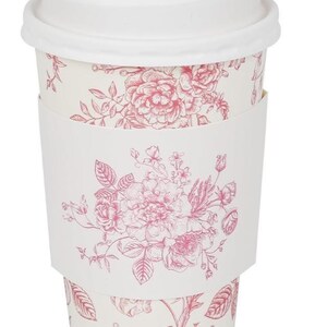 May include: A white disposable coffee cup with a matching lid and a pink floral design. The cup has a white sleeve with the same floral pattern. The floral design includes roses and other flowers.