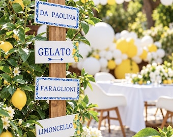 May include: A vertical wooden post features six rectangular white signs with blue text and lemon illustrations. The signs read CAPRI AYLA, DA PAOLINA, GELATO with an arrow, FARAGLIONI, LIMONCELLO, and LA FONTALINA with an arrow, all mounted on the post.