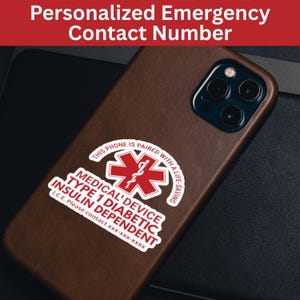May include: A brown phone case with a sticker that reads "MEDICAL DEVICE TYPE 1 DIABETIC INSULIN DEPENDENT" and "THIS PHONE IS PAIRED WITH A LIFE-SAVING". The sticker also includes an emergency contact number.