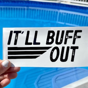Może przedstawiać: Biała naklejka z czarnym tekstem, który brzmi "IT'LL BUFF OUT" z czarnym wzorem pasów. Naklejka jest trzymana przed niebieskim basenem.