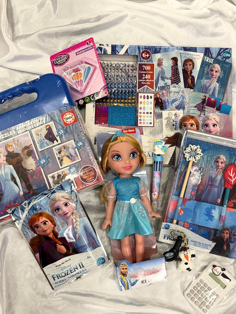 May include: A collection of Frozen II themed toys and crafts, including a doll in a blue dress, puzzles, sticker sets, and a small snowman figurine. The items are packaged in various boxes and containers, with the Frozen II logo visible.