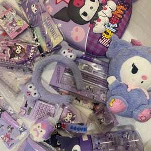 May include: A collection of purple Kuromi-themed school supplies and accessories. Items include a backpack, plush toys, a water bottle, a pencil case, a headband, and stationery. The items feature the Kuromi character and various designs.