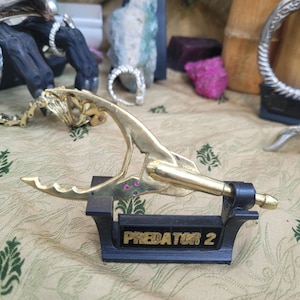 Punta de lanza Predator 2, fundida a mano con munición de latón para rifle. Es auténtica. Pesada y muy afilada. Con 6 rubíes.
